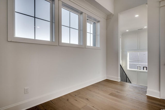 empty room with hardwood / wood-style flooring and plenty of natural light