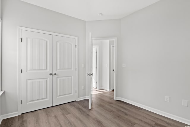 unfurnished bedroom featuring light wood-type flooring and a closet