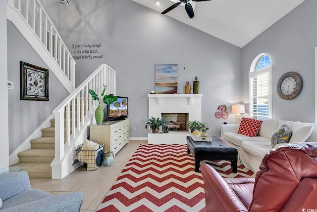 tiled living room featuring a fireplace, high vaulted ceiling, and ceiling fan