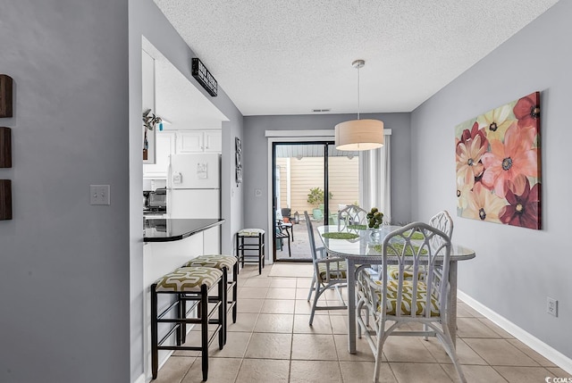 dining area with light tile patterned floors and a textured ceiling