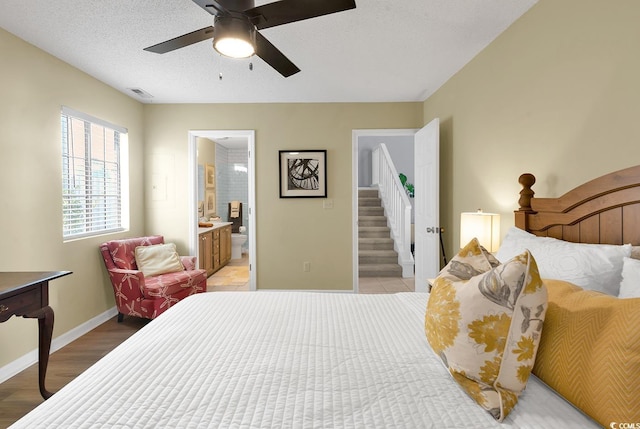 bedroom featuring ensuite bathroom, ceiling fan, a textured ceiling, and light hardwood / wood-style flooring