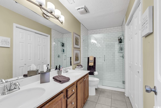 bathroom featuring vanity, tile patterned flooring, toilet, a textured ceiling, and an enclosed shower