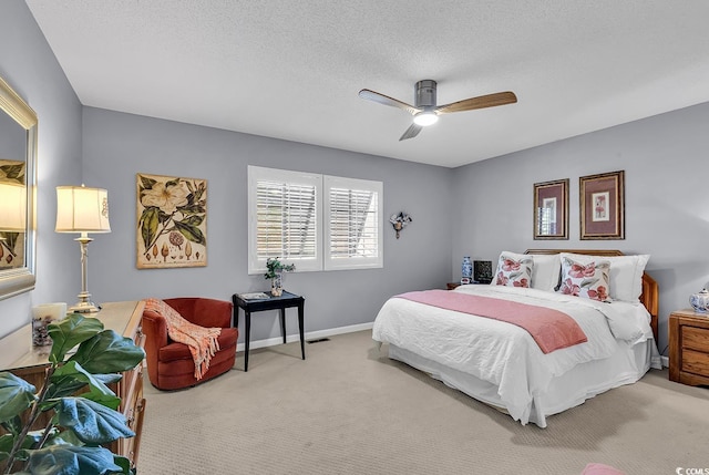 bedroom featuring a textured ceiling, carpet floors, and ceiling fan