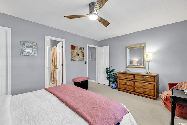 carpeted bedroom with ensuite bathroom and ceiling fan