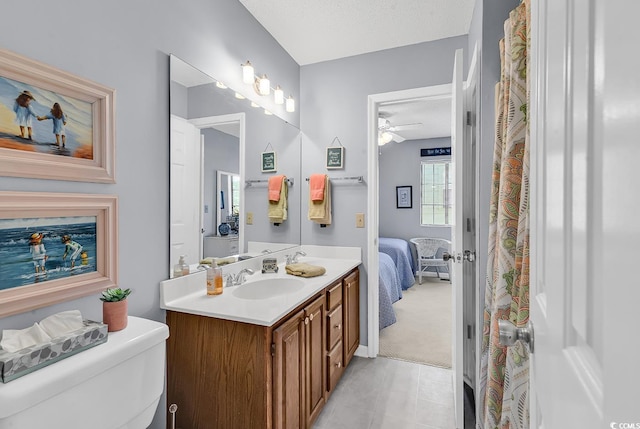 bathroom with ceiling fan, tile patterned flooring, a textured ceiling, toilet, and vanity