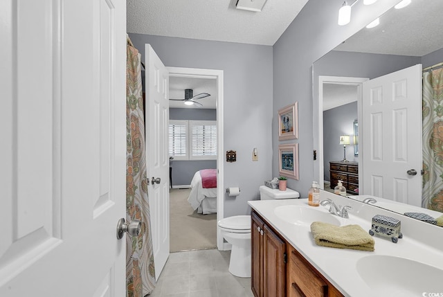 bathroom featuring vanity, tile patterned floors, ceiling fan, toilet, and a textured ceiling