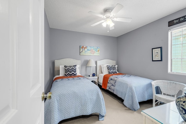 bedroom featuring a textured ceiling, carpet floors, and ceiling fan