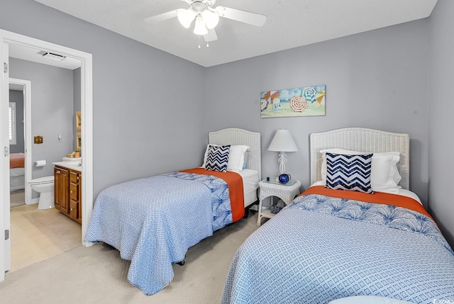 carpeted bedroom featuring ensuite bathroom and ceiling fan