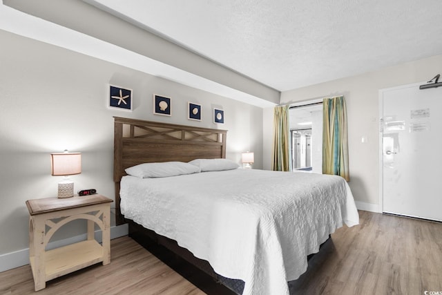 bedroom featuring hardwood / wood-style floors and a textured ceiling