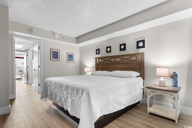 bedroom with wood-type flooring and a textured ceiling