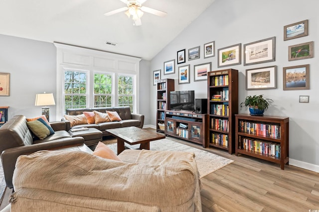 living room featuring ceiling fan, light hardwood / wood-style flooring, and vaulted ceiling