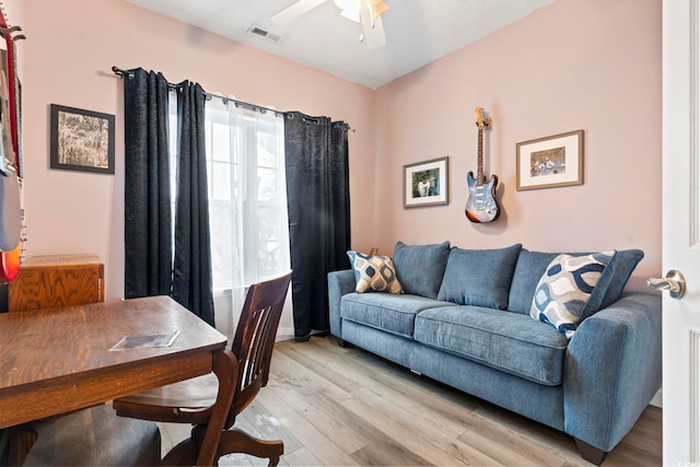 living room featuring light wood-type flooring and ceiling fan