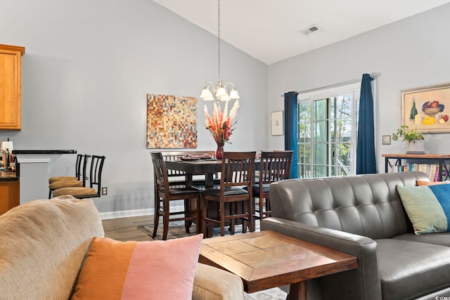 living room featuring dark hardwood / wood-style floors, vaulted ceiling, and a notable chandelier