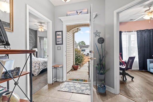 foyer entrance with ceiling fan and light hardwood / wood-style flooring