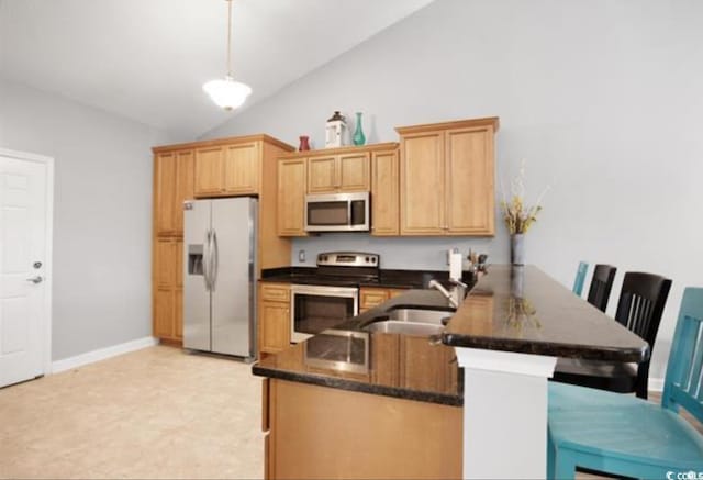 kitchen with a kitchen breakfast bar, kitchen peninsula, vaulted ceiling, and appliances with stainless steel finishes