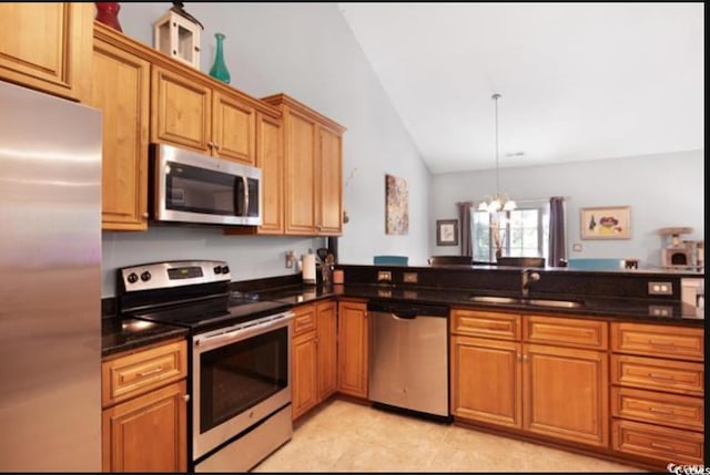 kitchen with kitchen peninsula, appliances with stainless steel finishes, vaulted ceiling, sink, and a chandelier