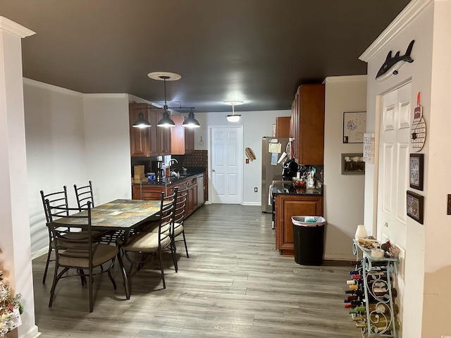 dining room with light hardwood / wood-style floors and crown molding