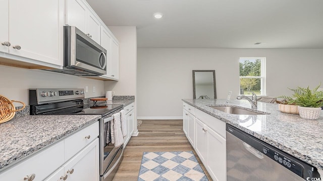 kitchen featuring white cabinetry, sink, light stone counters, and stainless steel appliances