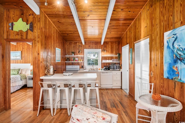 kitchen with wood ceiling, white dishwasher, beam ceiling, white cabinets, and range