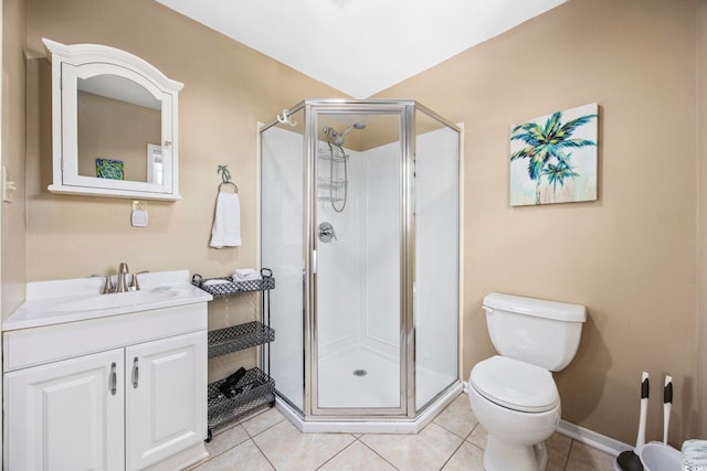 bathroom with tile patterned floors, vanity, a shower with shower door, and toilet