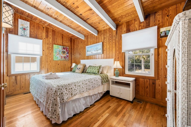 bedroom with beam ceiling, wooden walls, light hardwood / wood-style flooring, and wood ceiling