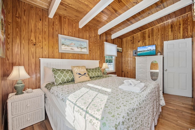 bedroom with beamed ceiling, hardwood / wood-style flooring, wood ceiling, and wood walls