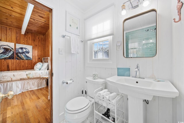 bathroom with wood-type flooring, wooden walls, toilet, and wooden ceiling