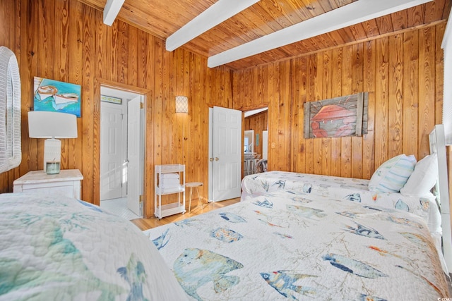 bedroom featuring beam ceiling, wood walls, wooden ceiling, and light hardwood / wood-style floors