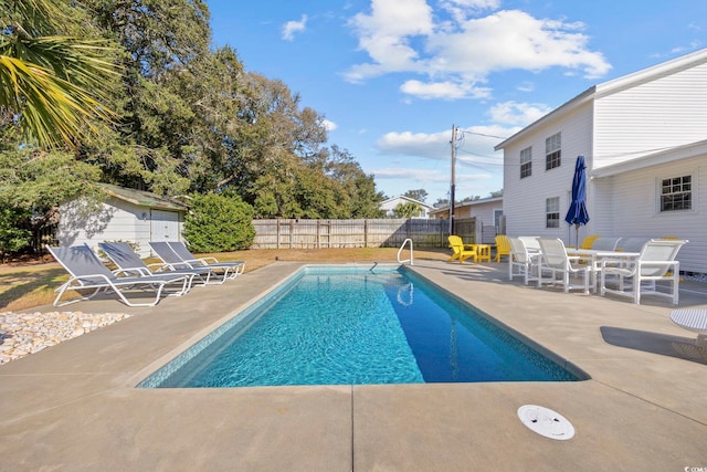 view of pool featuring a patio area and a shed