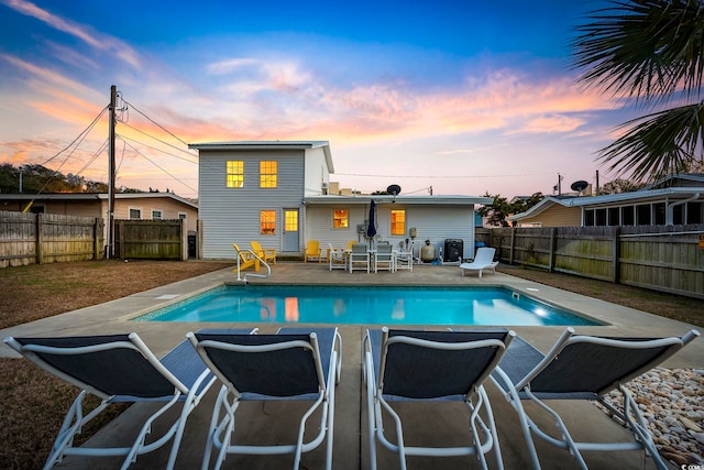 pool at dusk with a patio