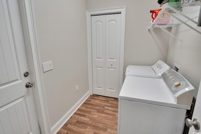 washroom with wood-type flooring and separate washer and dryer