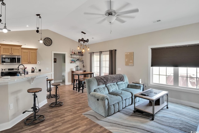 living room featuring ceiling fan, dark hardwood / wood-style flooring, and vaulted ceiling