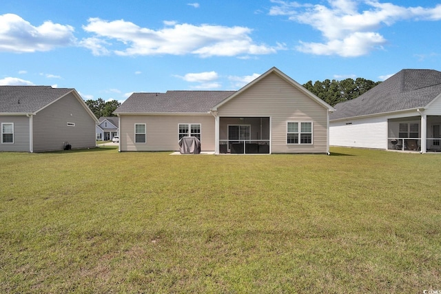 back of property featuring a sunroom and a yard