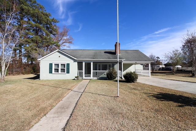 ranch-style home featuring a front lawn and a carport