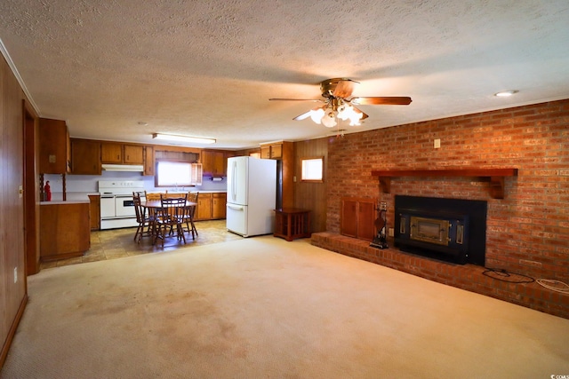 carpeted living room with a textured ceiling, a wood stove, and ceiling fan