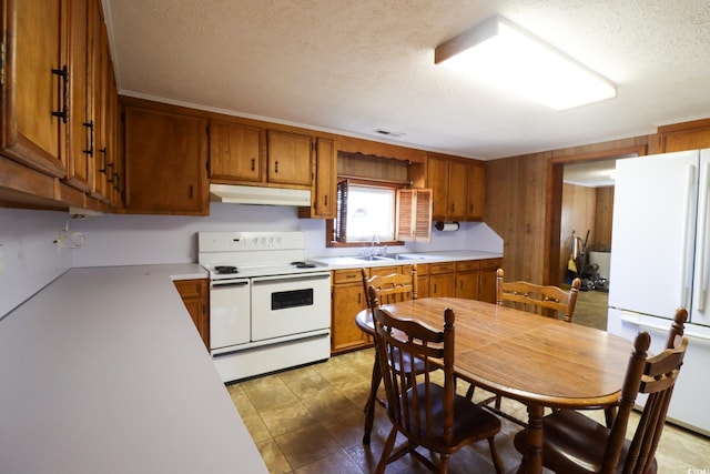 kitchen with a textured ceiling, sink, and white appliances