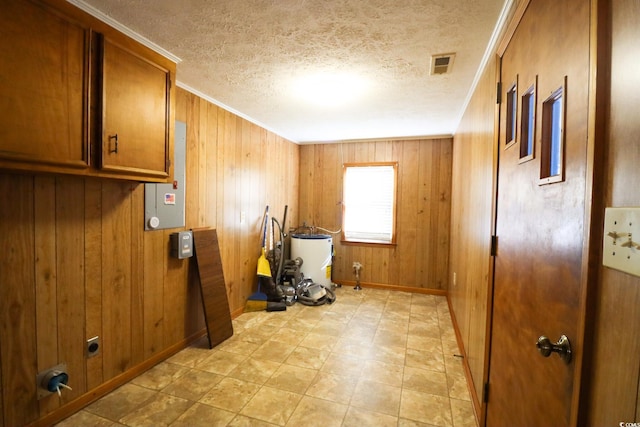 washroom with cabinets, a textured ceiling, crown molding, and wood walls