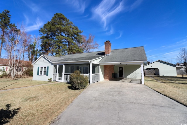 ranch-style house with a sunroom, a front yard, and a carport