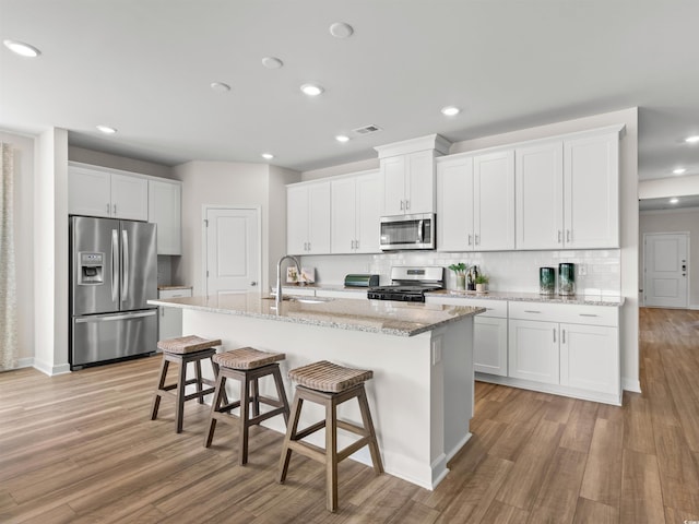 kitchen featuring white cabinets, appliances with stainless steel finishes, light hardwood / wood-style floors, and sink