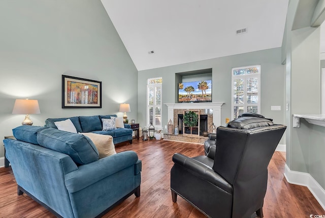 living room with hardwood / wood-style floors, a fireplace, and high vaulted ceiling