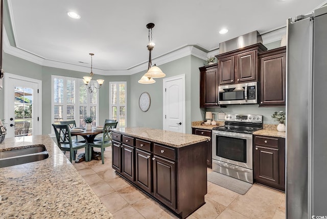 kitchen with pendant lighting, dark brown cabinetry, stainless steel appliances, and ornamental molding