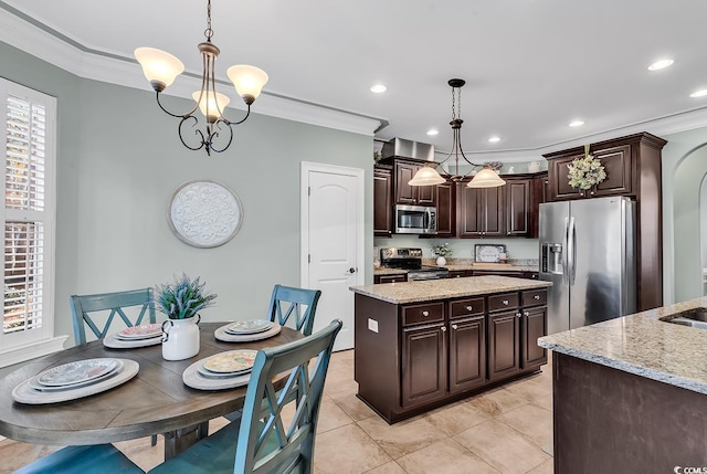 kitchen with appliances with stainless steel finishes, decorative light fixtures, dark brown cabinets, and a healthy amount of sunlight