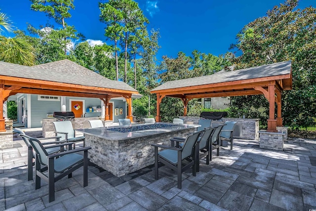 view of patio with a gazebo, area for grilling, a grill, and exterior bar