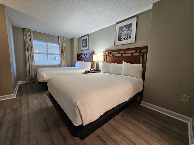 bedroom featuring a textured ceiling and dark hardwood / wood-style flooring