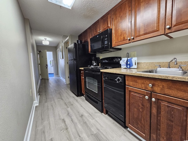 kitchen with black appliances, light tile patterned floors, sink, and a textured ceiling