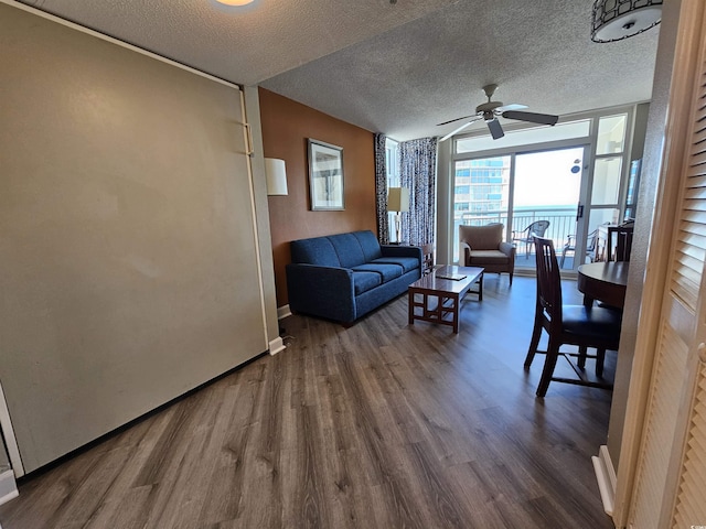 living room with hardwood / wood-style flooring, ceiling fan, and a textured ceiling