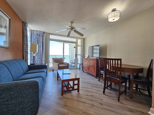 living room featuring hardwood / wood-style flooring, ceiling fan, floor to ceiling windows, and a textured ceiling