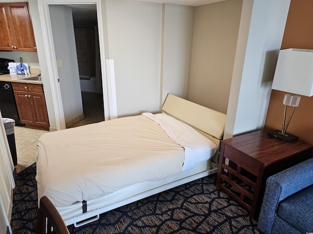 bedroom featuring light tile patterned floors, sink, and ensuite bath