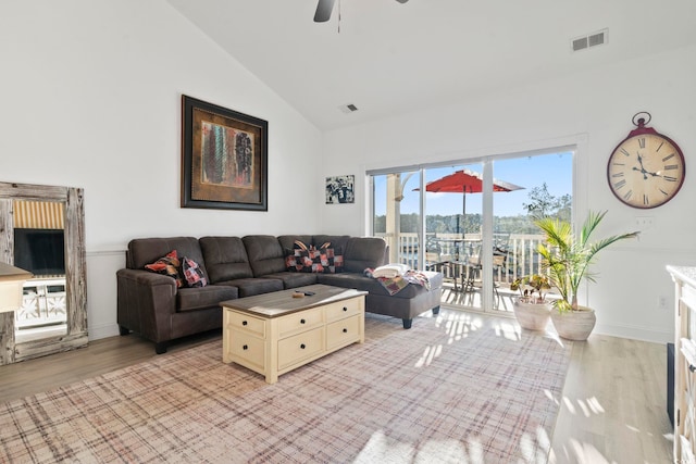 living room featuring ceiling fan, light hardwood / wood-style flooring, and high vaulted ceiling