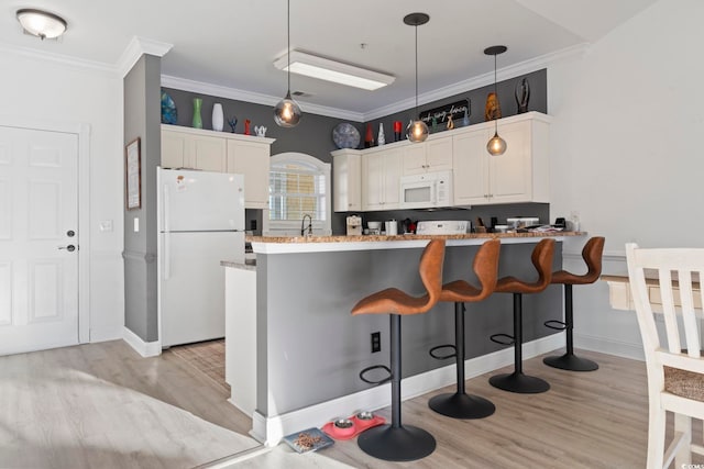 kitchen featuring kitchen peninsula, white appliances, decorative light fixtures, light hardwood / wood-style flooring, and white cabinetry